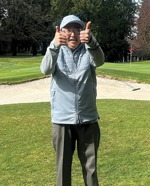 a man standing in the field, thumbs up