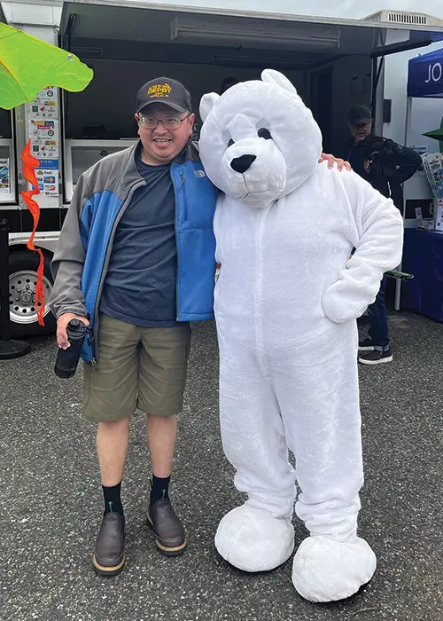 a man standing with a person who is wearing a white bear costume.
