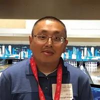 a man standing looking at camera, wearing glasses