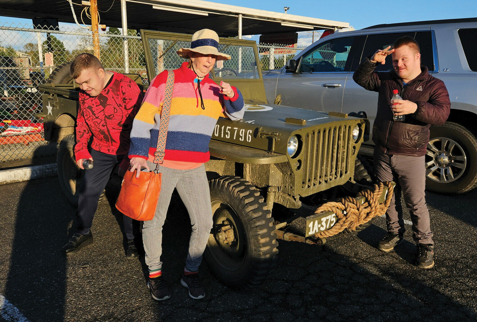Jim with his roommate and a friend in front of a Jeep.