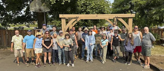 a group of volunteers standing in front of gazebo building in progress