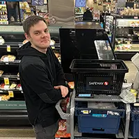 Max standing with a cart full of items. The shopping basket has Safeway logo.