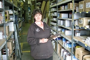 A woman holding a clipboard in a company setting.